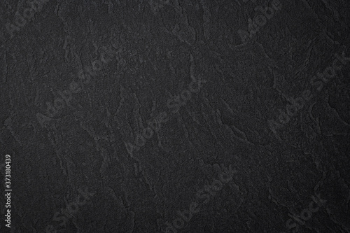 黒い岩肌のような質感のある紙の背景テクスチャー