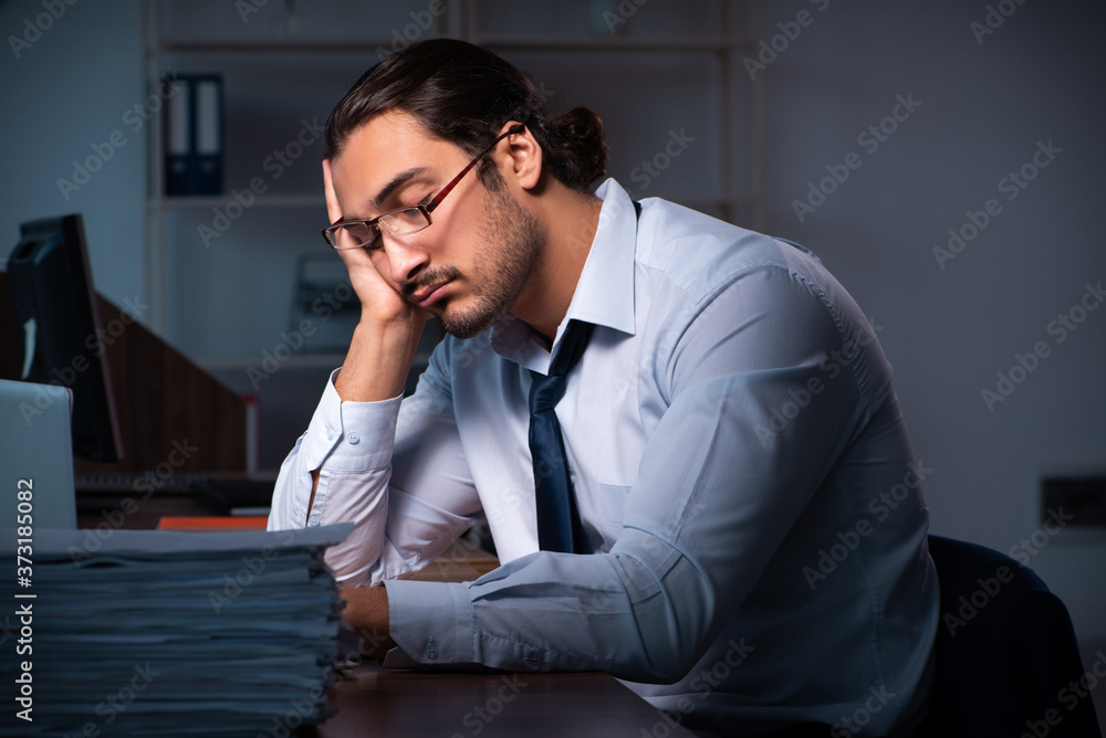 Young male employee working in the office night time Young male employee working in the office night time