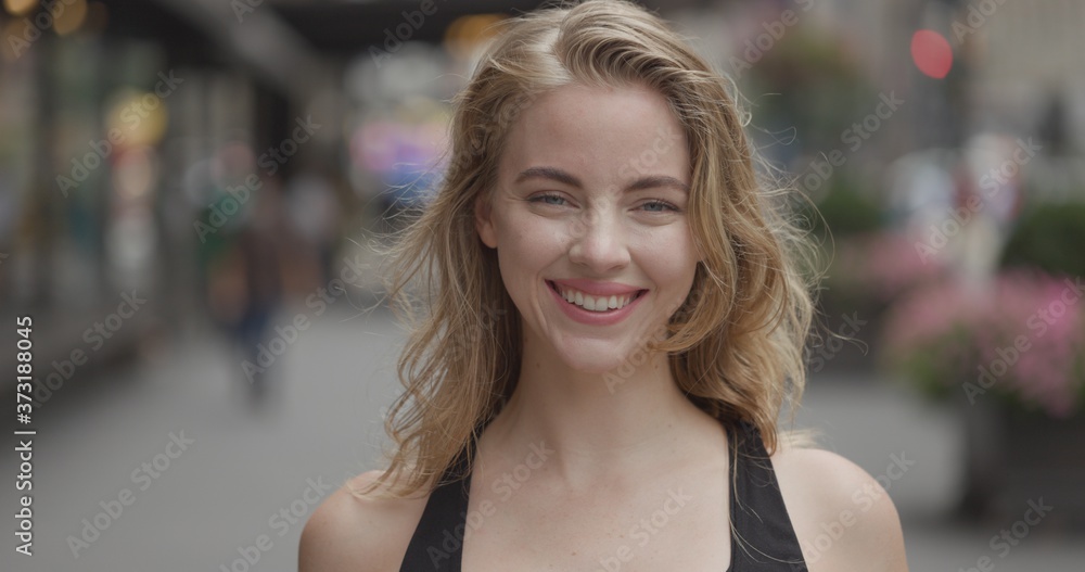 Young blond woman in city face portrait smile happy