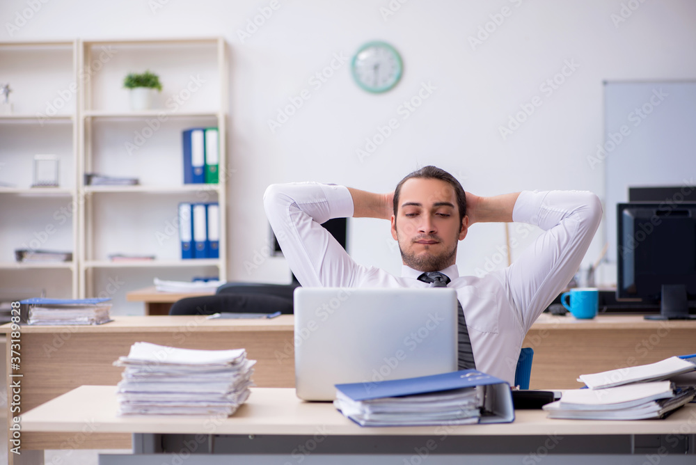 Young male employee unhappy with excessive work Young male employee unhappy with excessive work