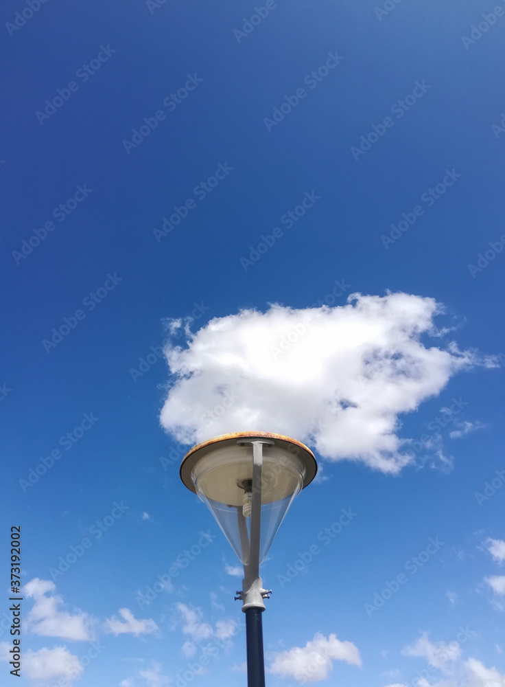 light pole off with a cloud above