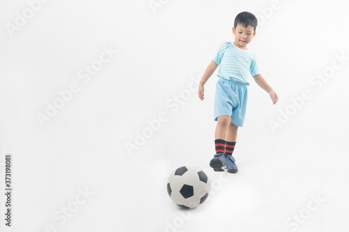 Young Asian boy kick football isolated on white background © khwanchai