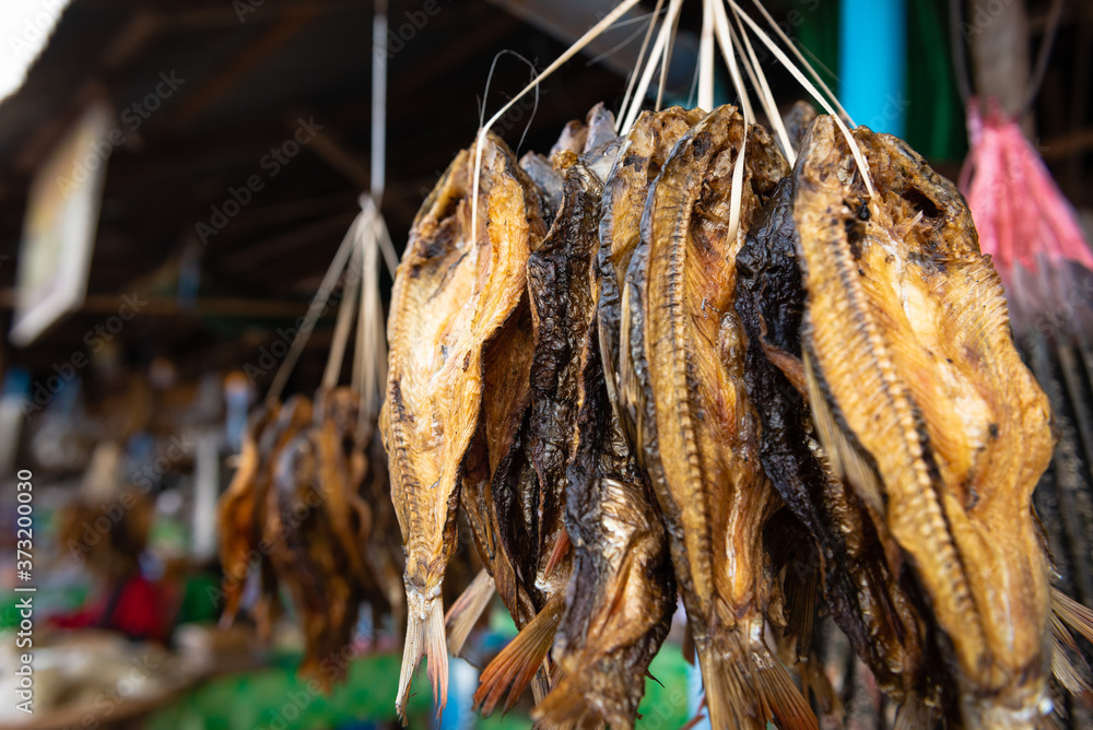 Dried fish hanging at a market stall at a fish market in rural Laos