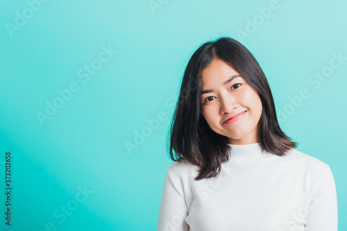 Portrait of Asian teen beautiful young woman Wear a white T-shirt smile clean skin, female beauty face concept, studio shot isolated on a blue background © sorapop