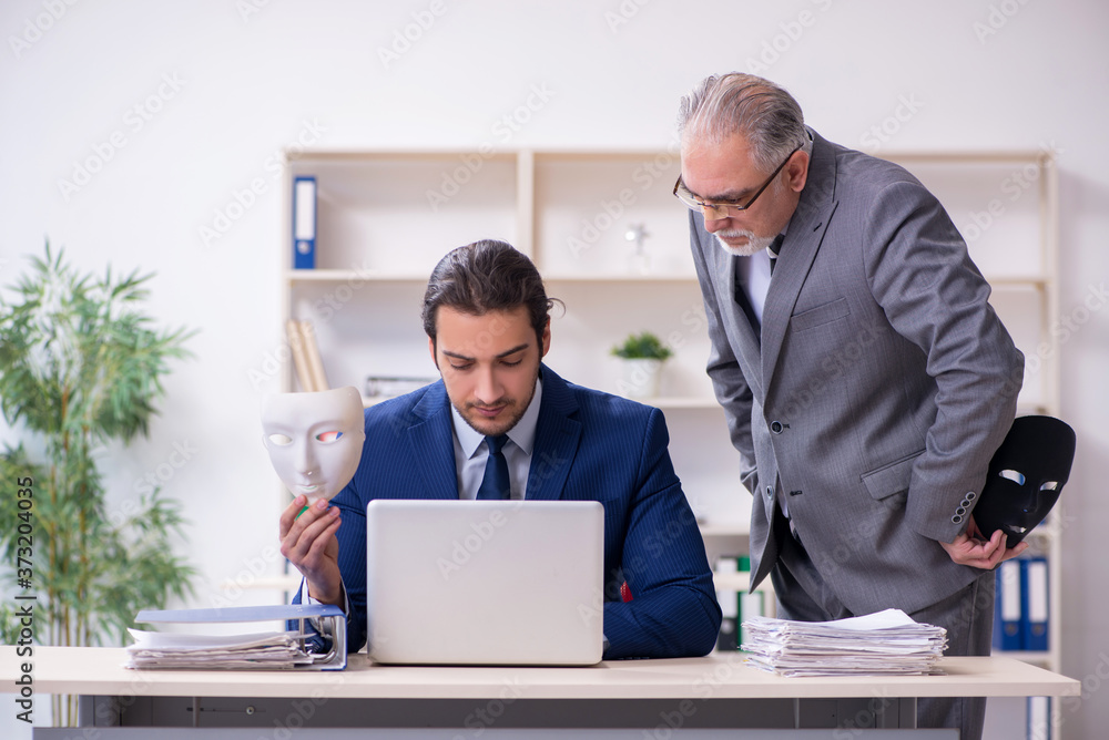 Old boss and young male employee wearing masks Old boss and young male employee wearing masks