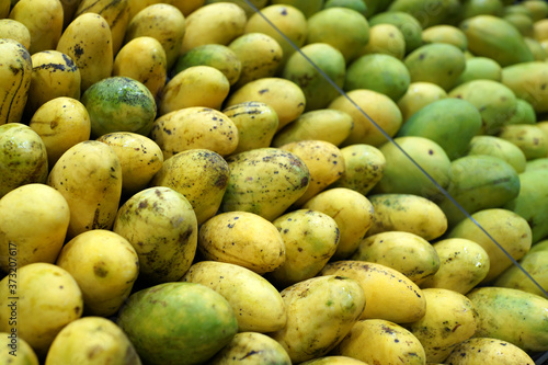 Fresh mangoes from Thailand display on market stall for sale
