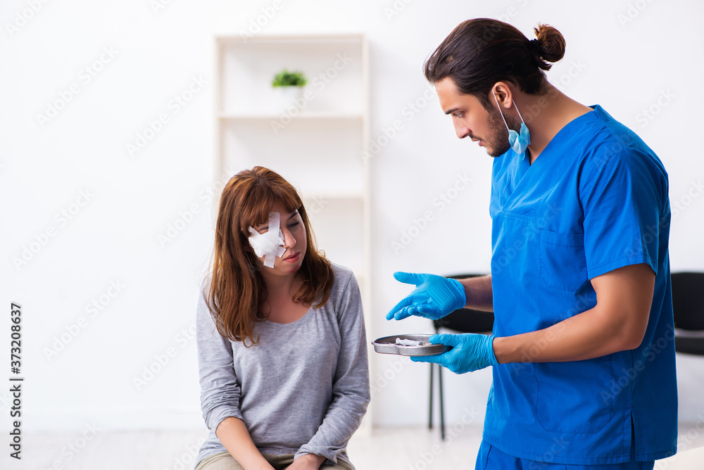 Obraz premium Young head injured woman visiting young male doctor