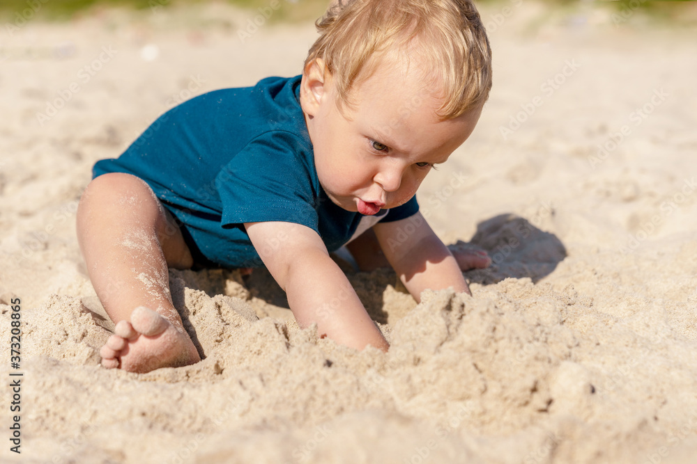 Little boy playing in the sandy Baltic sea beach. Post Quarantine family vacation in native resort. Little boy playing in the sandy Baltic sea beach. Post Quarantine family vacation in native resort.