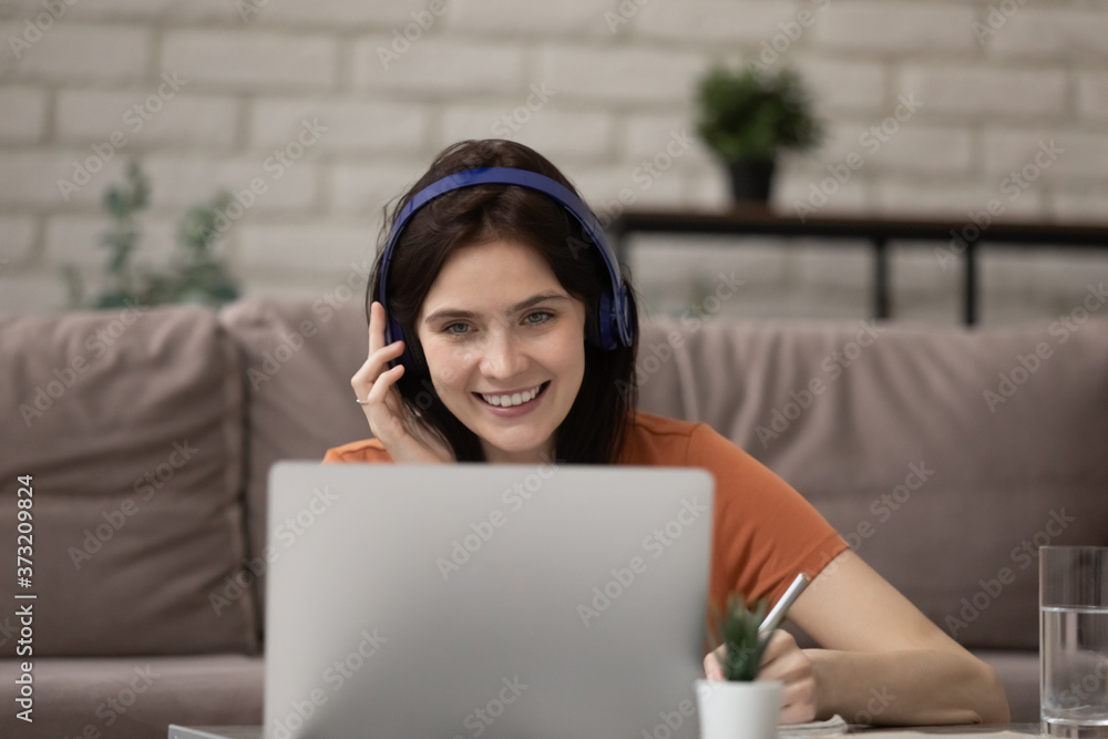 Happy young Caucasian woman in headphones take online course or training on laptop at home, smiling millennial girl in earphones watch webinar study on web on computer, distant education concept Happy young Caucasian woman in headphones take online course or training on laptop at home, smiling millennial girl in earphones watch webinar study on web on computer, distant education concept