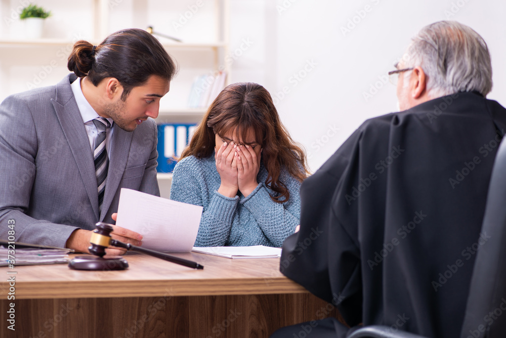 Young woman in courthouse with judge and lawyer Young woman in courthouse with judge and lawyer