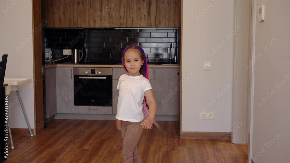 Cute girl with multicolored pigtails whirls. Having fun at home. Cute girl with multicolored pigtails whirls. Having fun at home.