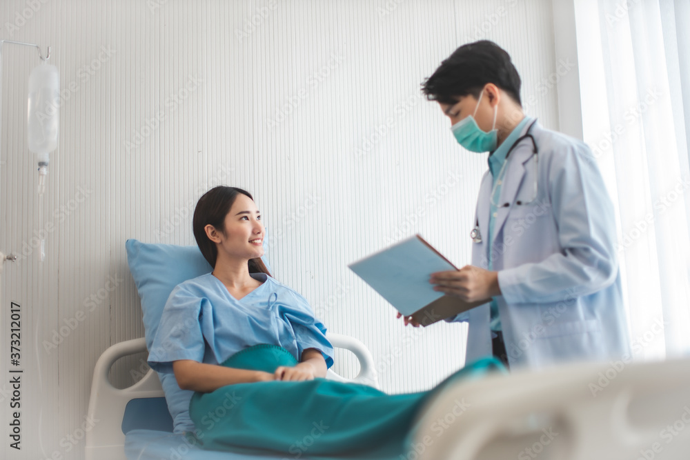 Obraz premium Medicine and health care concept. Asian doctor is taking care patient woman in hospital.doctor or nurse wear protection mask checking and takecare infection people from covid-19 .