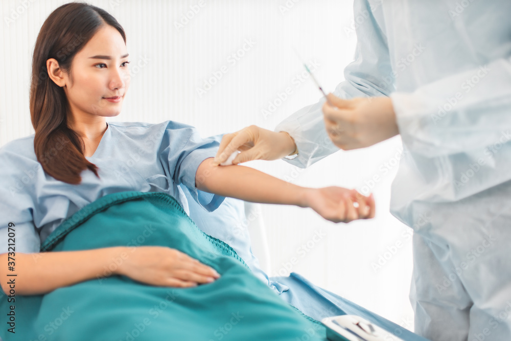 Fototapeta premium Medicine and health care concept. Asian doctor is taking care patient woman in hospital.doctor or nurse wear protection mask checking and takecare infection people from covid-19 .