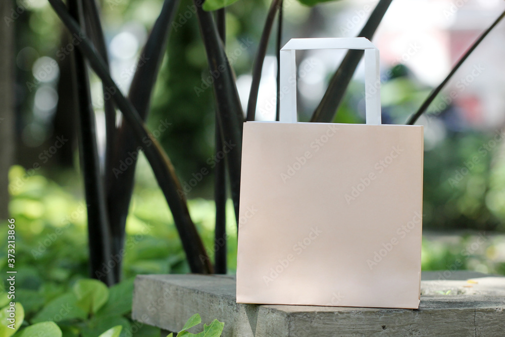 Light brown single paper bag on cement surface in garden Light brown single paper bag on cement surface in garden