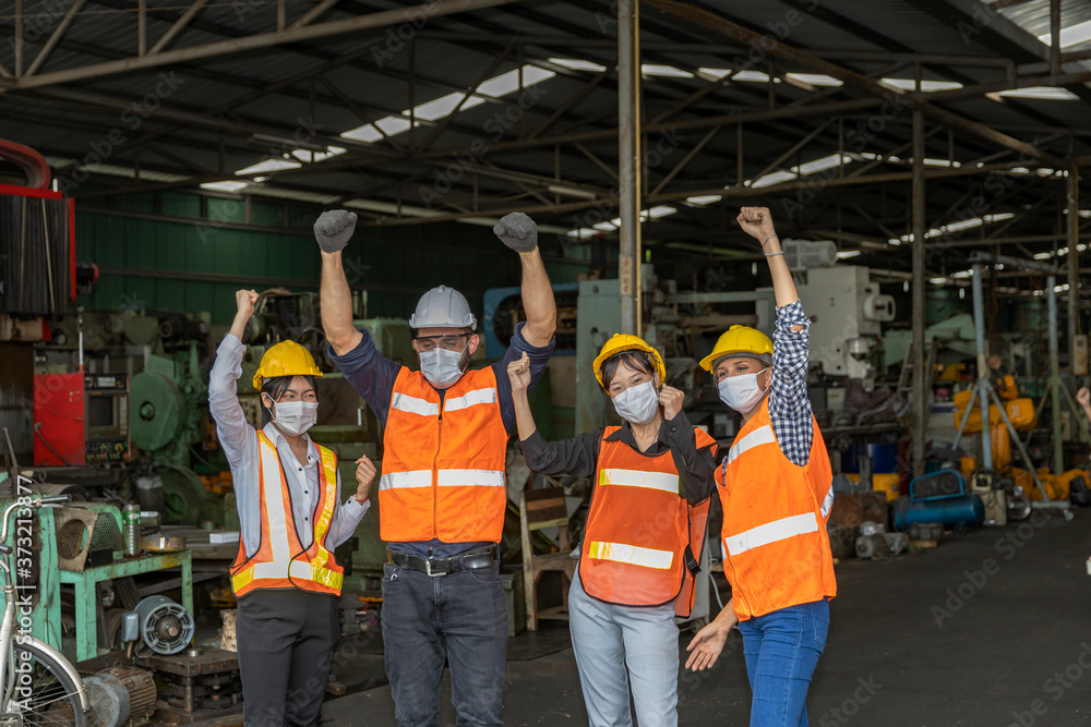 Team of mechanic engineers with face mask celebrate a great success during COVID-19 outbreak. Group of technicians are very happy with business results after Coronavirus crisis Team of mechanic engineers with face mask celebrate a great success during COVID-19 outbreak. Group of technicians are very happy with business results after Coronavirus crisis