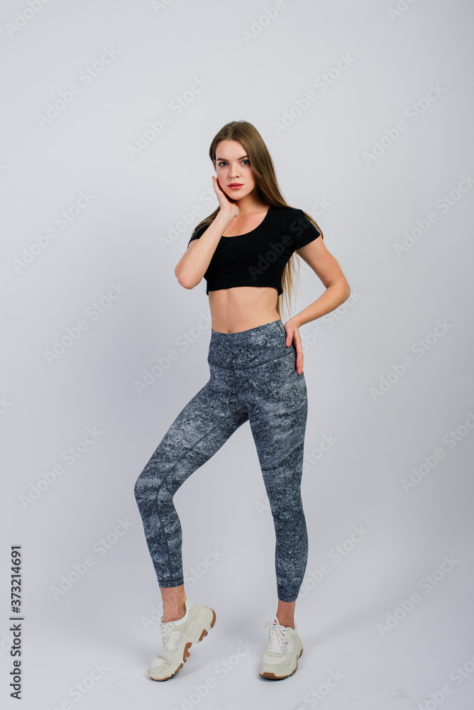 Healthy lifestyle: full length portrait of smiling young fitness girl in perfect shape, studio shot, white background Healthy lifestyle: full length portrait of smiling young fitness girl in perfect shape, studio shot, white background