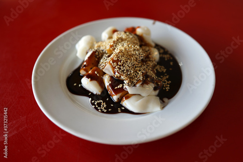 A plate of rice noodle roll with sweet sauce and chili paste also known as Chee Cheong Fun  Cantonese dish  Dim Sum meal.