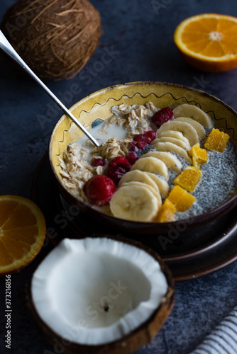 Oatmeal with chia seed, bananas and oranges served in a bowl