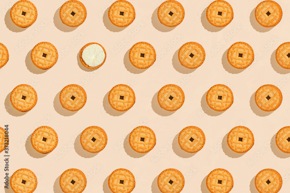 Biscuits stuffed with cream on a bright yellow background, a recurring seamless pattern, sweet background, wallpaper. Copy space, banner. top view