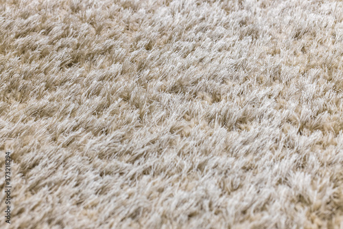 The texture of a long pile of gray artificial carpet. Focus with a shallow depth of field.