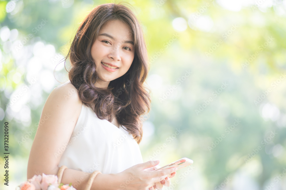 Beautiful fashion women use smartphone in green city park Beautiful fashion women use smartphone in green city park