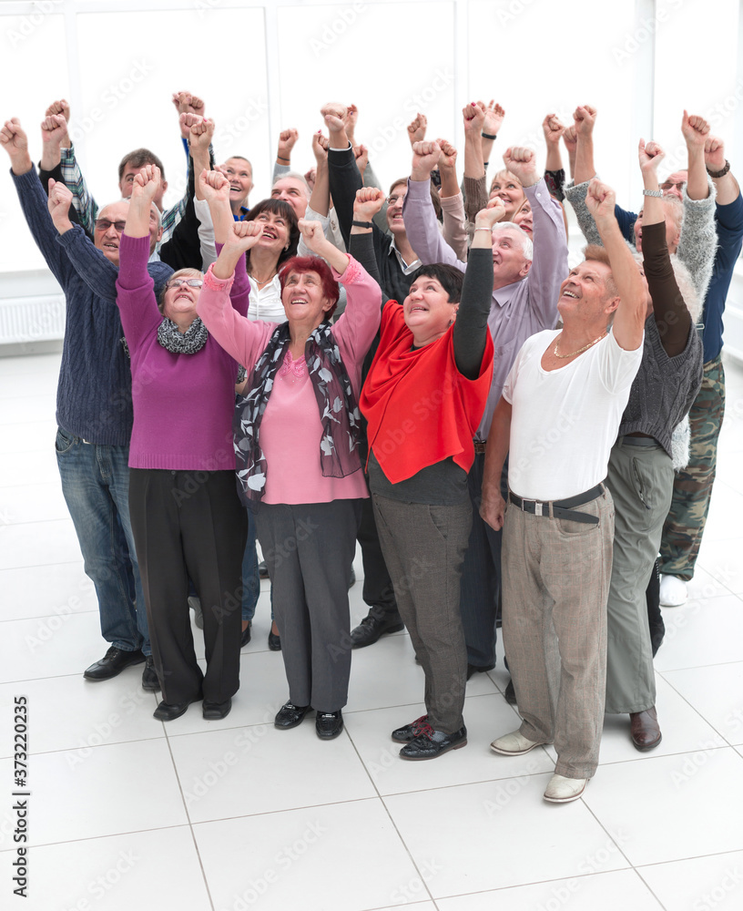 a group of elderly people raised their hands up