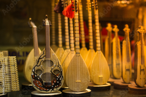 Closeup of small baglama souvenirs on shelves under the lights with a blurry background photo