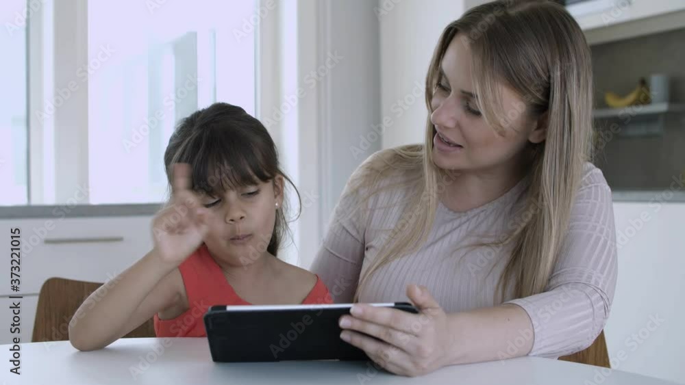 Mom using tablet and for training daughter studying skills. Medium shot. Preschool education at home concept Mom using tablet and for training daughter studying skills. Medium shot. Preschool education at home concept