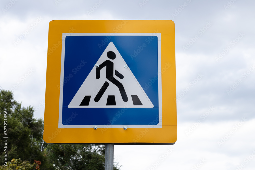 Pedestrian crossing road sign in yellow frame on blue sky, symbol of crosswalk on street. Pedestrian crossing road sign in yellow frame on blue sky, symbol of crosswalk on street.
