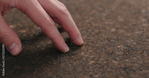 man hand touch dark cork surface with oil finish © GCapture