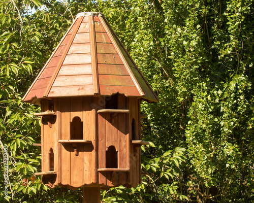 Close up of wooden dovecote on summer day against green foliage © Martin and Dawn Q