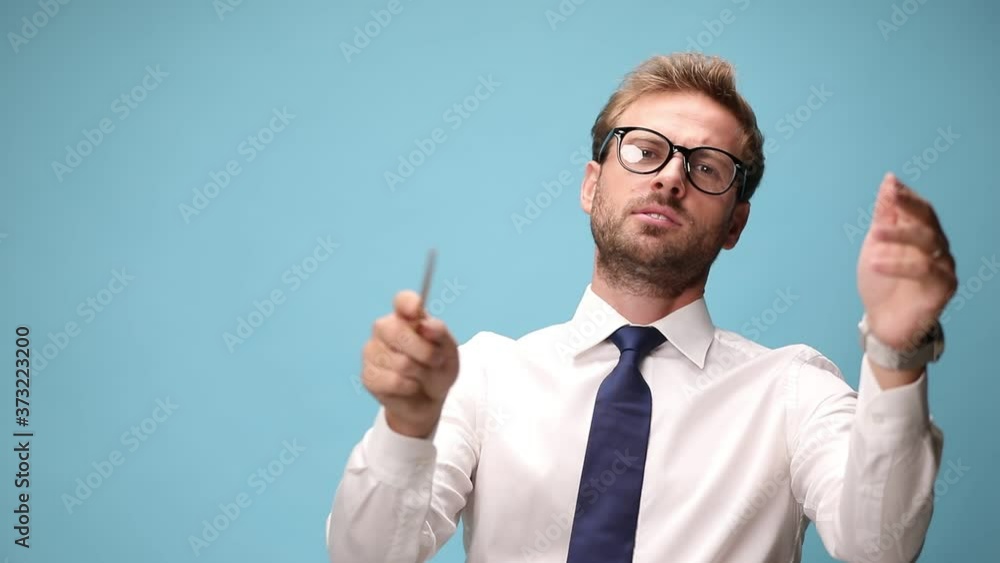 handsome businessman leading an orchestra gently on blue background handsome businessman leading an orchestra gently on blue background