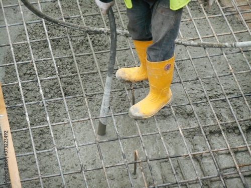 Canvastavla SELANGOR, MALAYSIA -JUNE 18, 2016, : Construction workers using a concrete vibrator at the construction site to compact the concrete slurry that pours in the form work