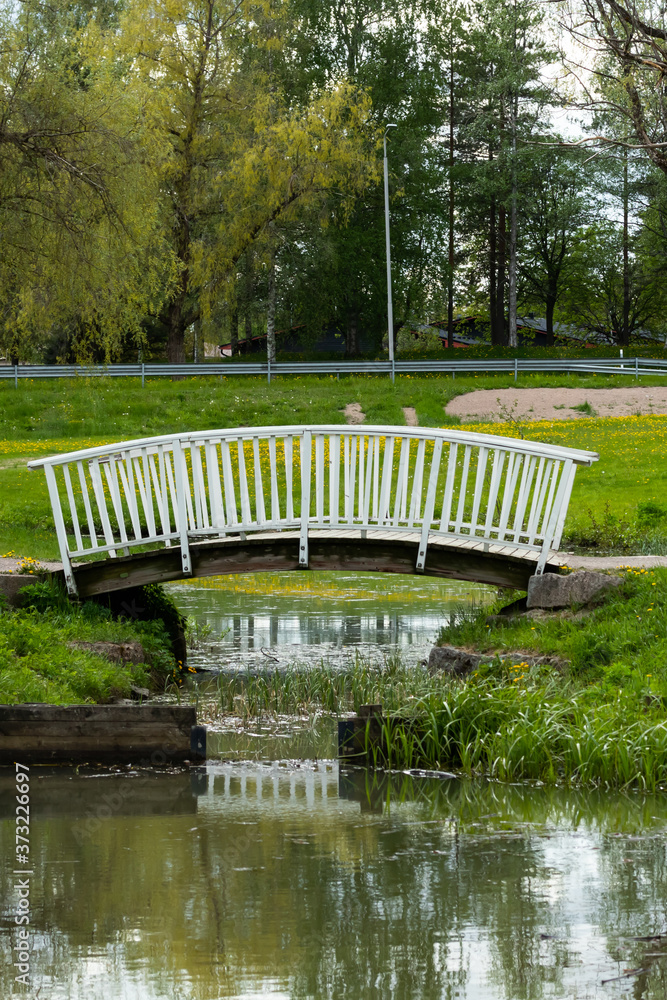 Landscape with spring pond and wooden bridge in the park Landscape with spring pond and wooden bridge in the park