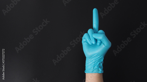 Man is wearing blue latex gloves and do the middle finger hand sign.Use it when you want to say "fuck you".