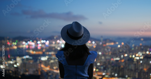 Wall Mural Woman look at the beautiful city view at sunset