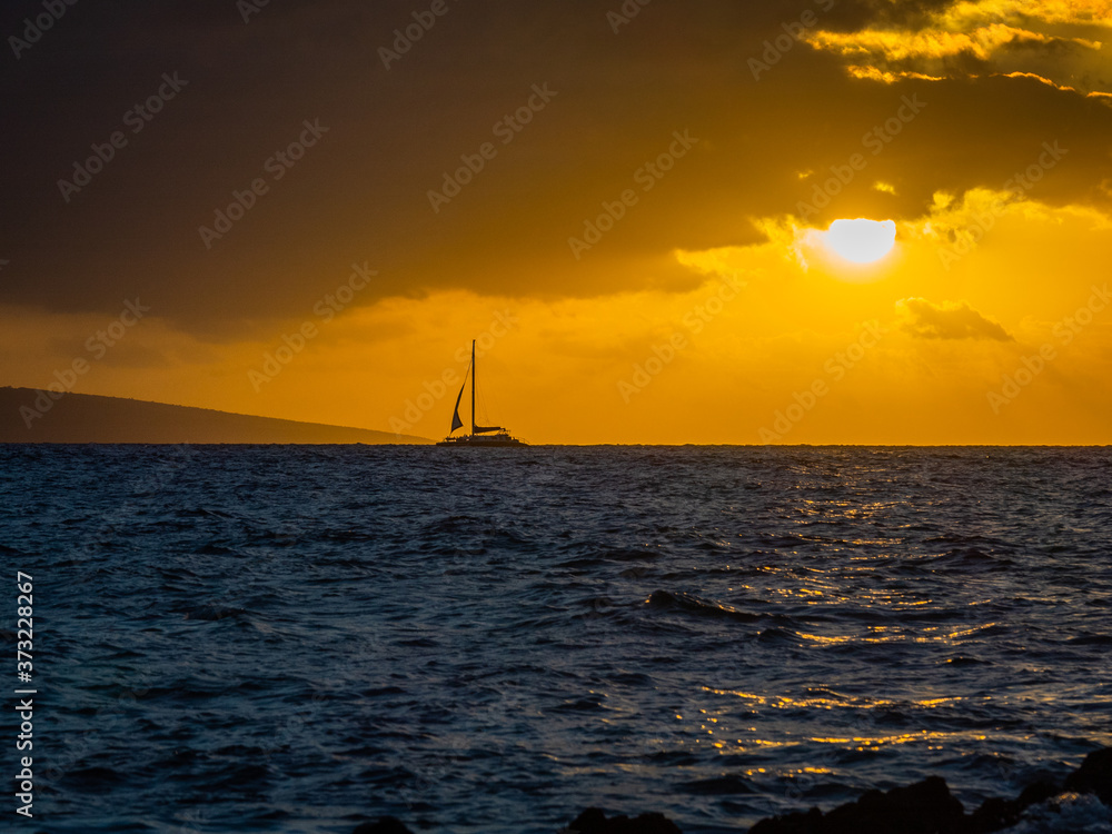 Amazing sunset and boat on the horizon. Beautiful nature of Hawaii
