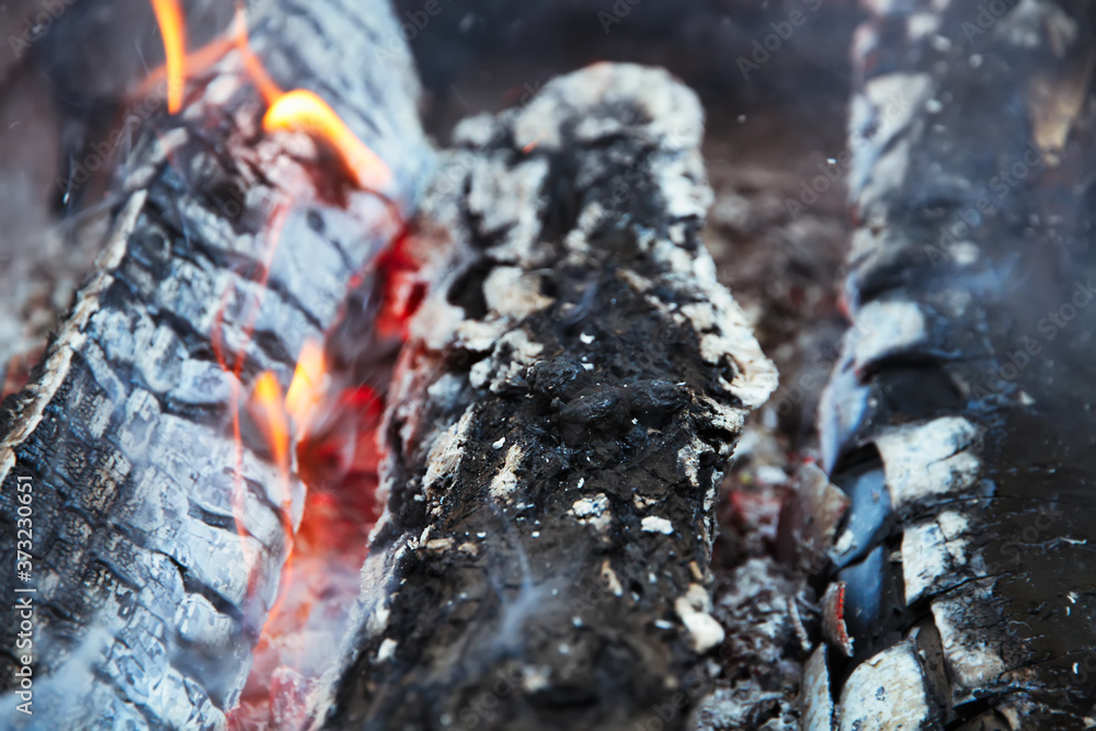 Glowing embers in hot red color, abstract background. The hot embers of burning wood log fire. Firewood burning on grill. Texture fire bonfire embers. Glowing embers in hot red color, abstract background. The hot embers of burning wood log fire. Firewood burning on grill. Texture fire bonfire embers.