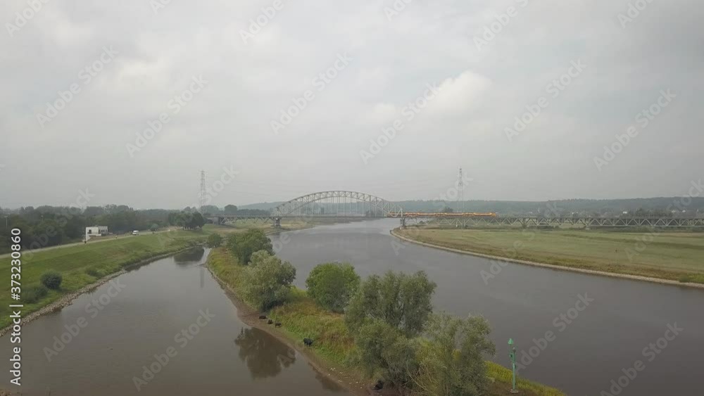 Aerial of Arnhem Railway bridge in Holland over the river Rhine with a yellow train Aerial of Arnhem Railway bridge in Holland over the river Rhine with a yellow train