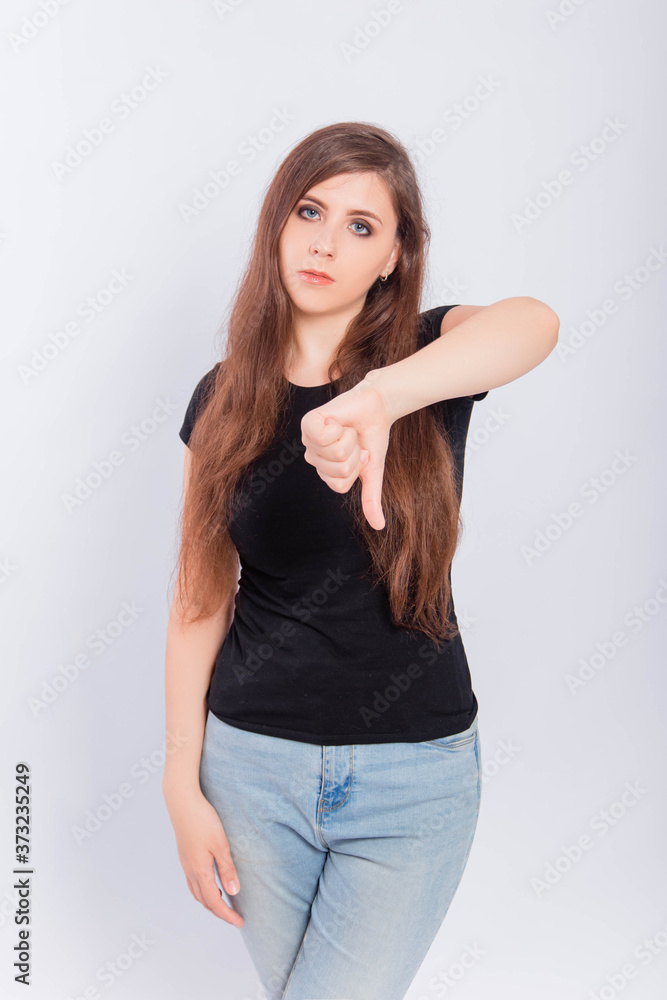 Young woman in black t-shirt showing thumb down gesture isolated on white background. Young woman in black t-shirt showing thumb down gesture isolated on white background.