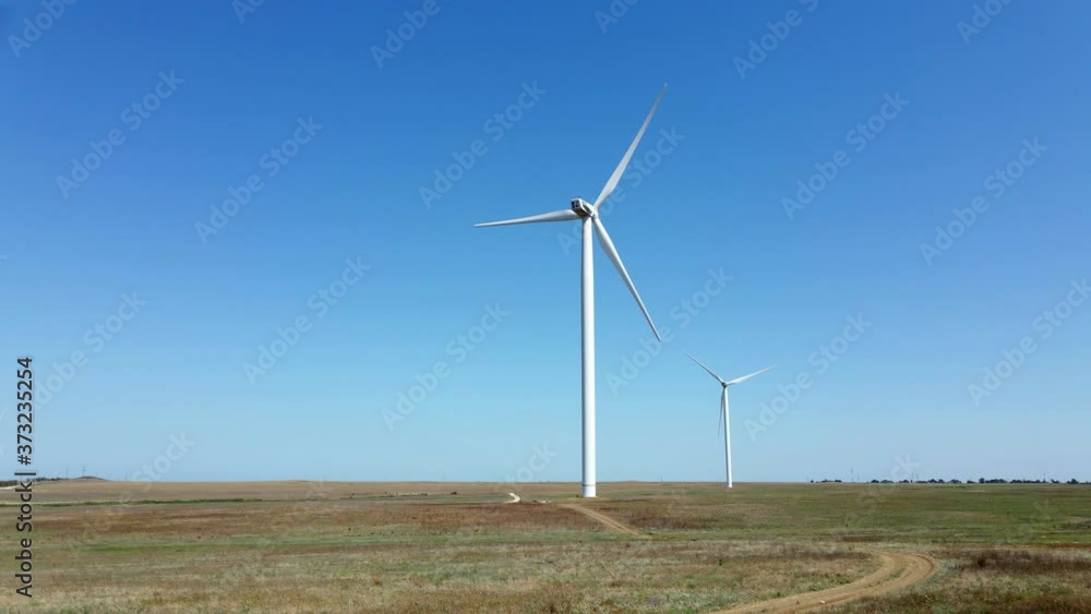 working wind turbines standing on the field in summer in Russia working wind turbines standing on the field in summer in Russia
