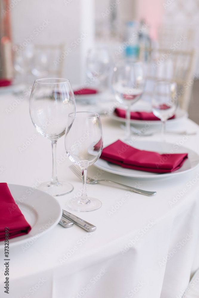 Elegant table setting for wedding celebration in restaurant. Vertical shot, light colors.