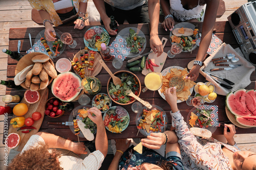 Fotografie High angle view of group of people sitting at the table and have dinner they cel