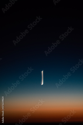 Crescent moon in the multicolored sky and amazing sunset
