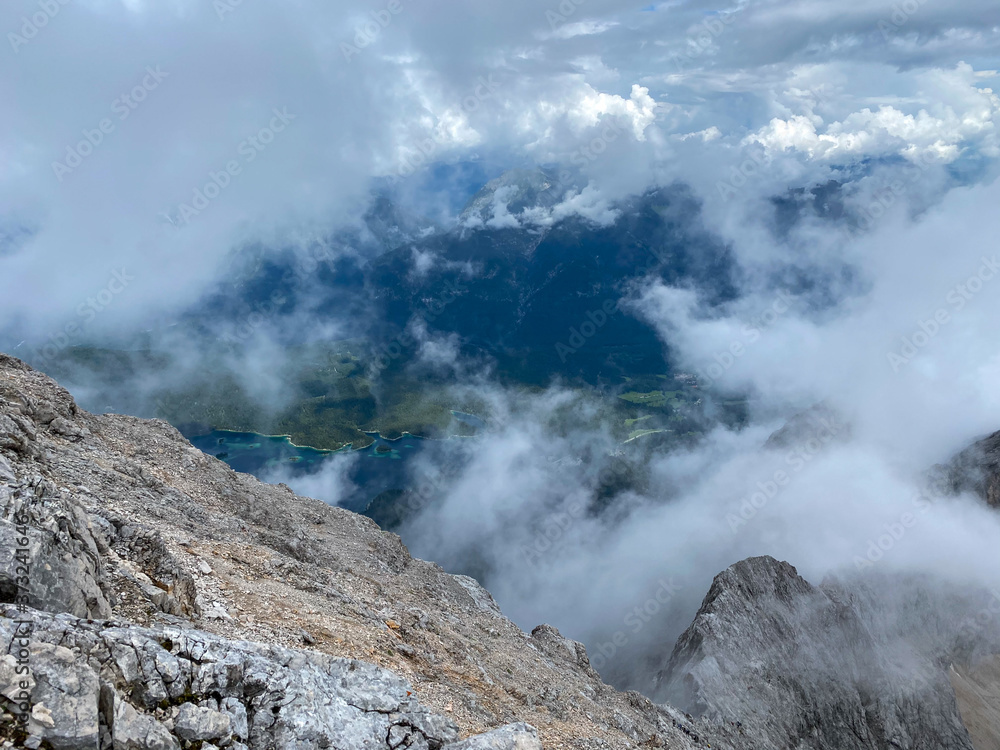 Man Hiking to the top of Germany with a stunning view to the alpine rocks in Germany