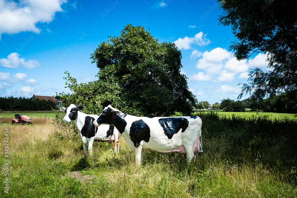 Zwei Kühe aus Plastik auf einer Wiese Zwei Kühe aus Plastik auf einer Wiese