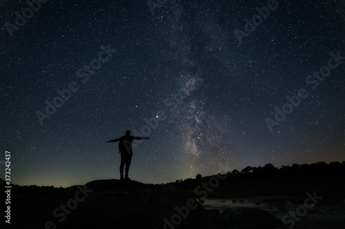 Night landscape with Milky Way and human silhouette.