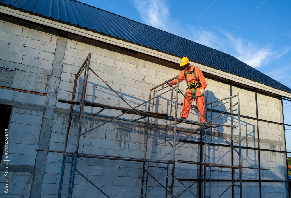 Roofer worker in protective uniform wear and safety line working install new roof at construction site.