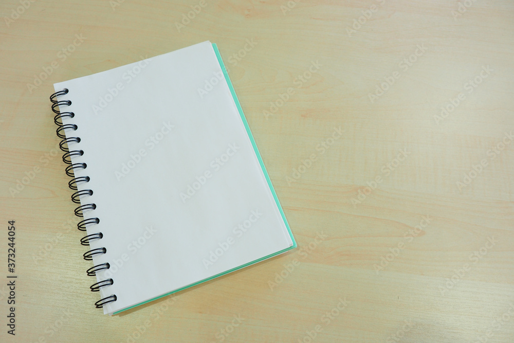 Notebook with white blank page open on the wooden table for add text in simple and neat style Notebook with white blank page open on the wooden table for add text in simple and neat style