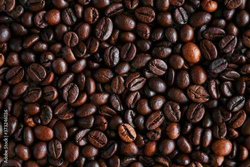 Background of roasted dark aromatic coffee beans  which make an invigorating coffee drink. The view from the top.